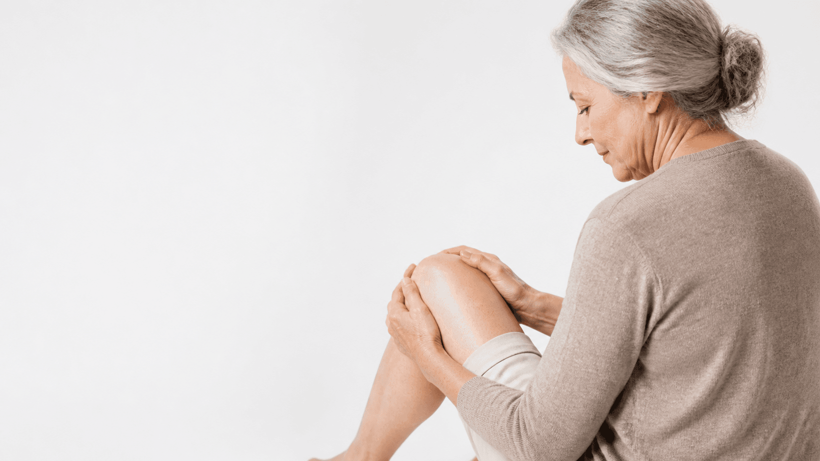 Older adult gently holding a knee