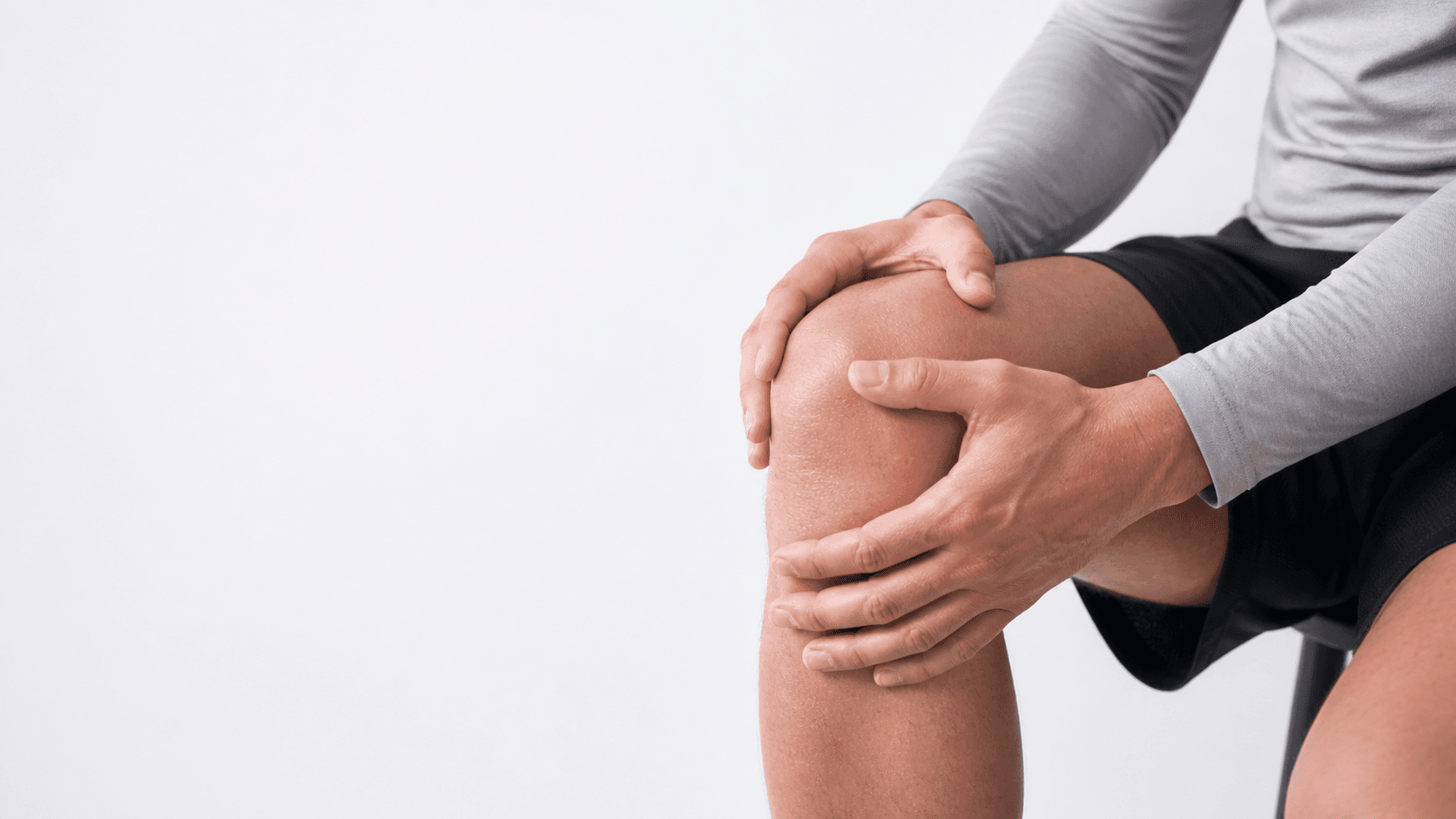 Person gently holding a knee with both hands